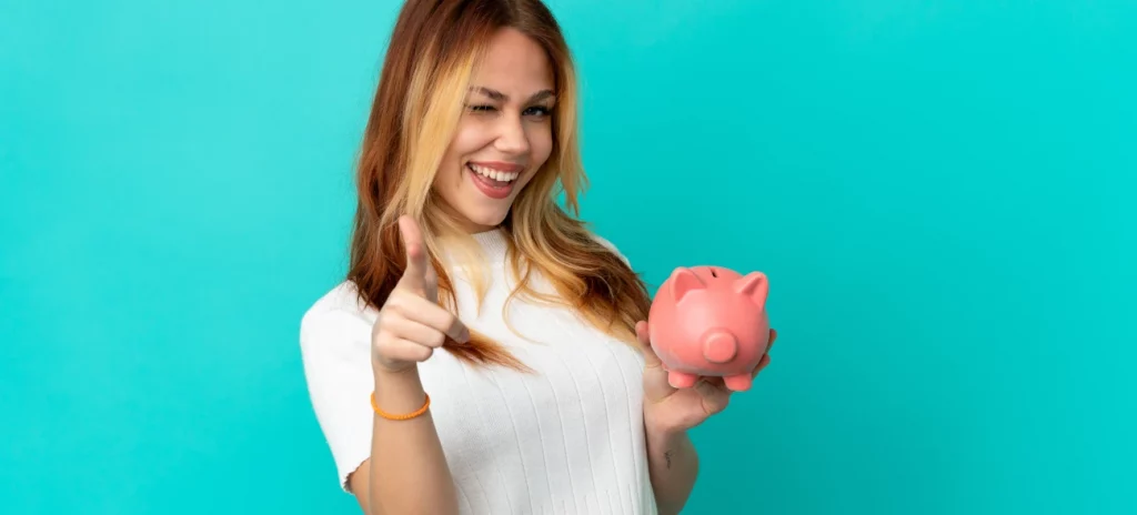 Frau mit Sparschwein und zuversichtlichem Lächeln hat ihre Finanzen im Griff – als Symbol für den Start in die finanzielle Sicherheit.