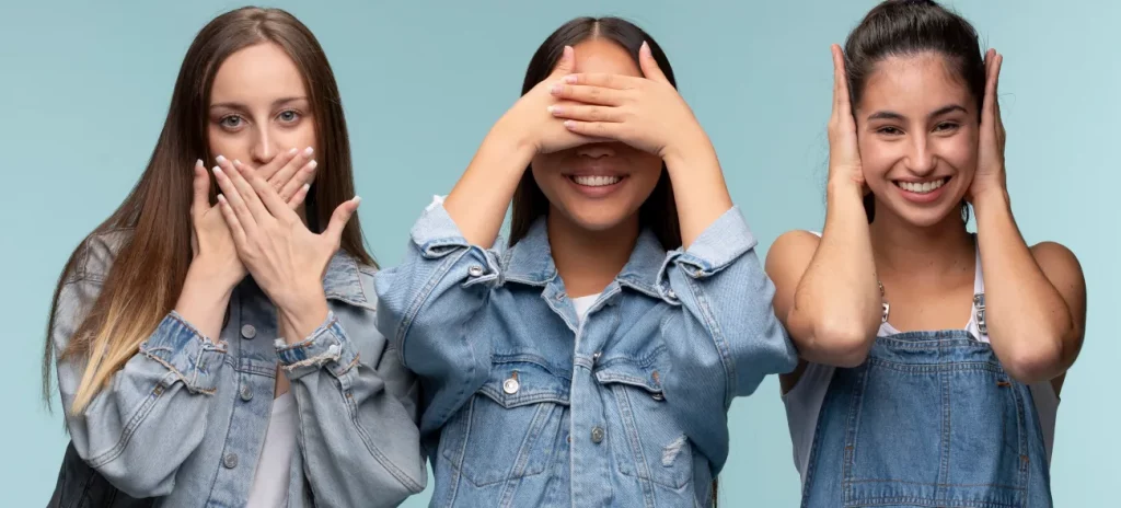 Drei junge Frauen zeigen symbolisch die Gesten „nichts sehen, nichts hören, nichts sagen“: Wer bevorstehende Systemwechsel ignoriert, macht sich selbst handlungsunfähig.