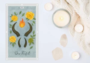 Energie der Tarotkarte „Der Teufel“. Abgebildet auf weißem Untergrund, umgeben von zwei weißen Kristallen und Teelichtern. Die Karte zeigt zwei Paar Teufelshörner, flankiert von drei gelben und einer grünen Rose sowie einer roten-orangenen Flamme in der Mitte der oberen Hörner.