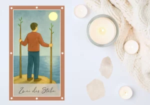 Eine Tarotkarte im Aquarellstil zeigt einen Mann auf einem Felsplateau am Meer. Er steht mit dem Rücken zum Betrachter und hält in jeder Hand einen der beiden gleich langen Stäbe, die fest auf dem Boden stehen und oben kleine grüne Triebe tragen. Am Himmel über dem ruhigen, blaugrauen Wasser leuchtet ein heller Mond.